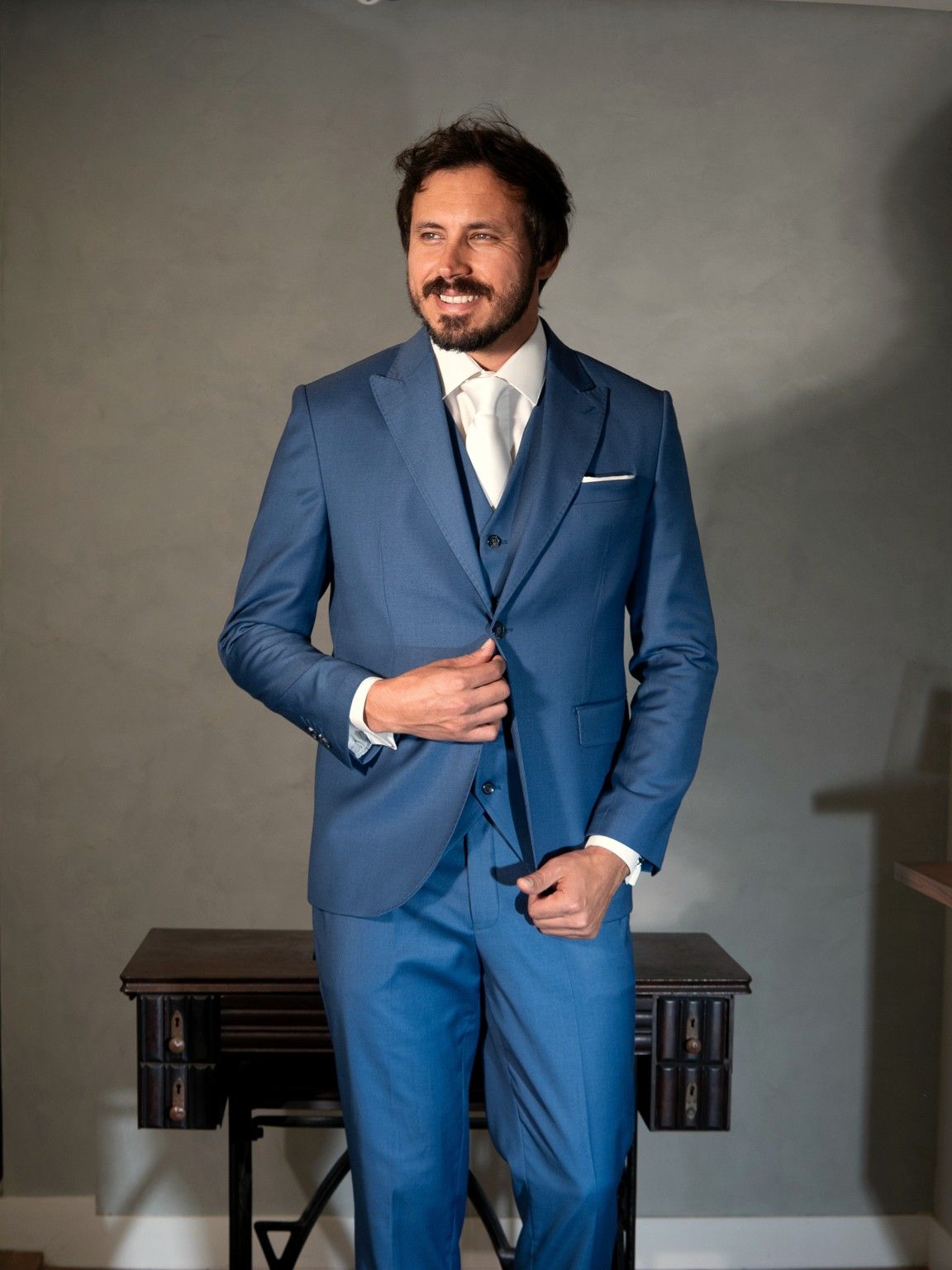 Terno azul royal com colete, gravata clara e lenço no bolso